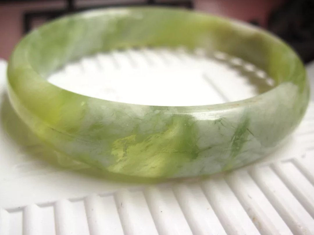 昨天在北京十三陵的蛇纹玉手镯佩戴后发现黑点淡了慢慢分散,里面出现了白色云朵,是怎么回事啊？